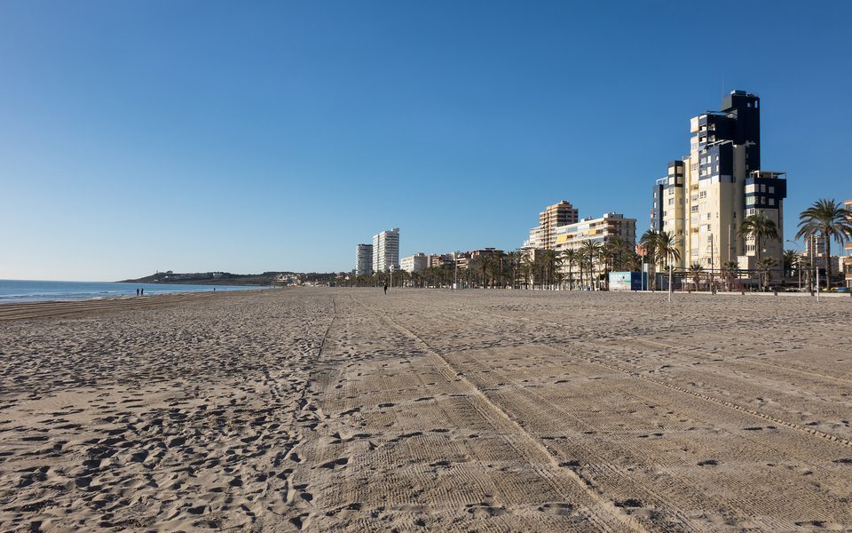 Den brede Playa de San Juan med sand, promenade og boliger langs kysten
