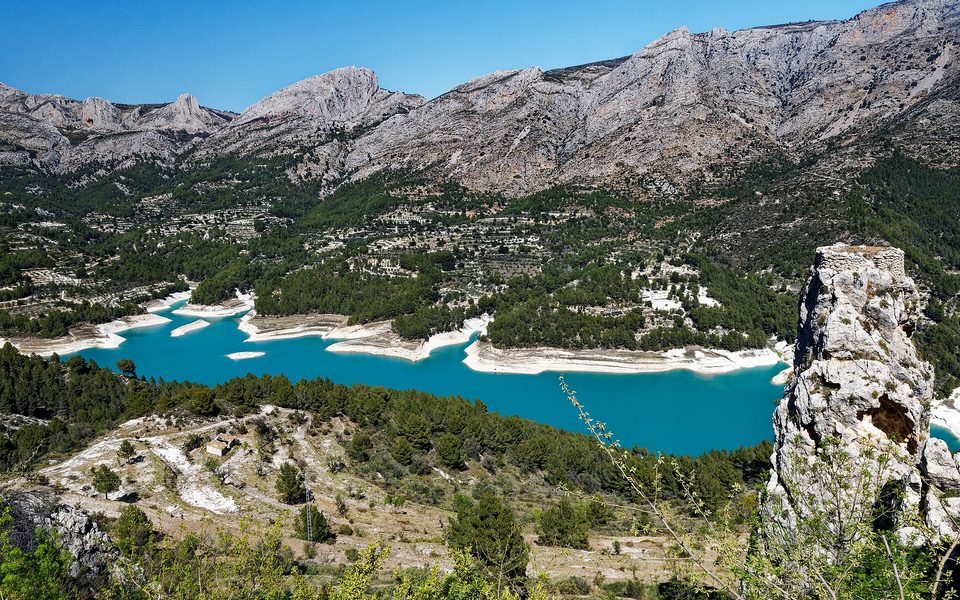 Guadalest-reservoiret mellem fyrreskov, dyrkningsland og bjergene i Marina Baixa